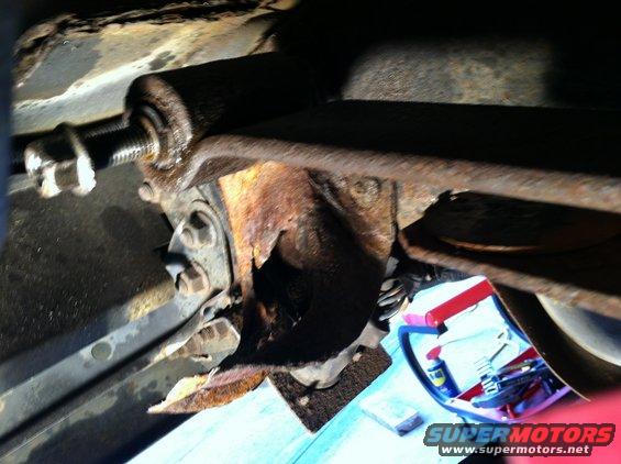 Rusted spring hanger bracket on a 1996 Ford Bronco, showing significant corrosion and damage