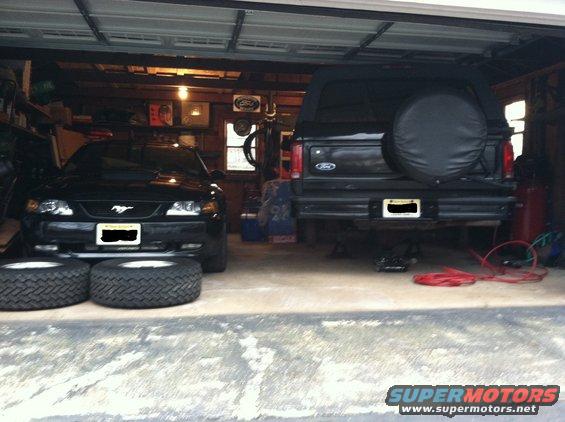 Black Ford Bronco rear view with spare tire cover, license plate, and trailer hitch