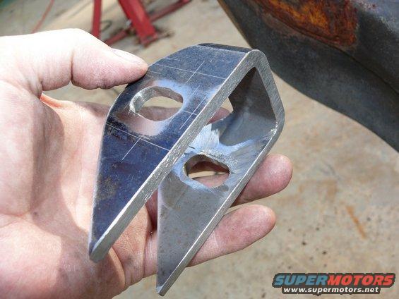 Metal bracket with two holes held in hand, Supermotors.net logo visible