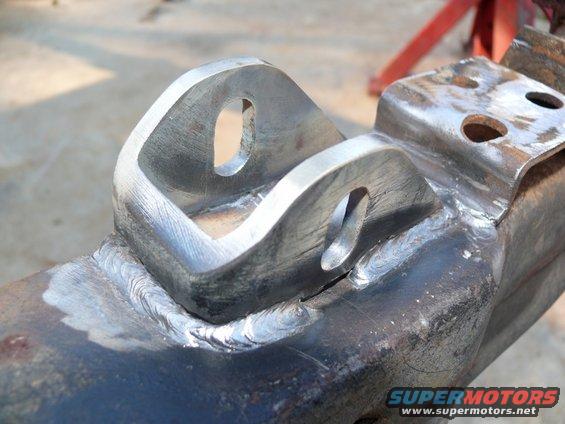 Welded metal bracket with two holes, part of a vehicle frame