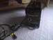 2003 Ford Crown Victoria - A black welding machine with various controls and attached cables is shown on a carpeted floor.