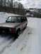 1991 Land Rover Range Rover - A 1991 Land Rover Range Rover navigates a snow-covered mountain path, with trees and snow-capped peaks in the background.
