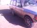 1991 Land Rover Range Rover - Side view of a 1991 Land Rover Range Rover parked outdoors on a dirt surface.