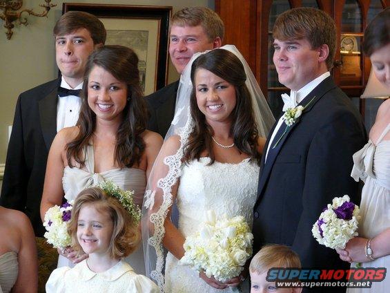 Wedding party with bride and groom, bridesmaids, and a flower girl