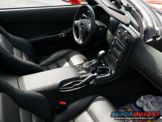 Interior shot of a Corvette, showing black leather seats, center console with shifter, and dashboard