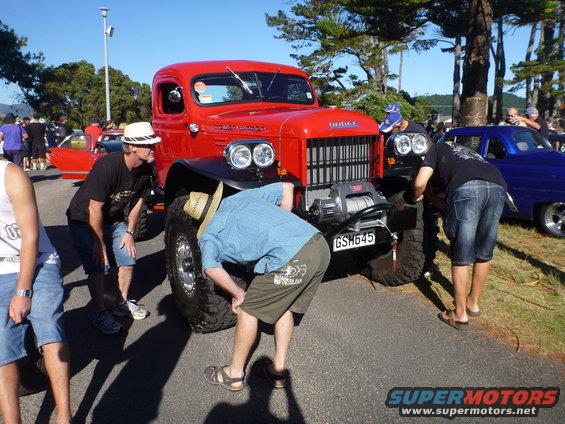 Red Dodge Power Wagon truck with winch, people examining it