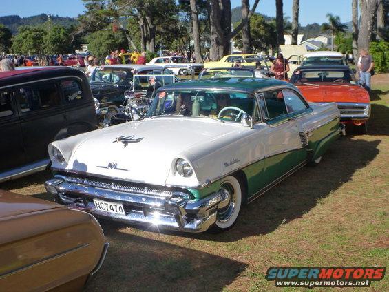 Two-tone white and green coupe with chrome grille and whitewall tires