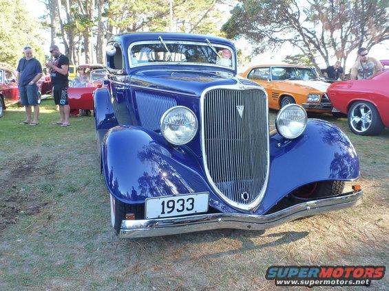 Blue 1933 car front view with chrome grille and headlights