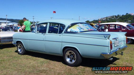 Light blue sedan rear view with chrome trim and custom wheels