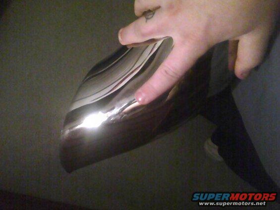 Chrome bumper with reflections, finger touching surface