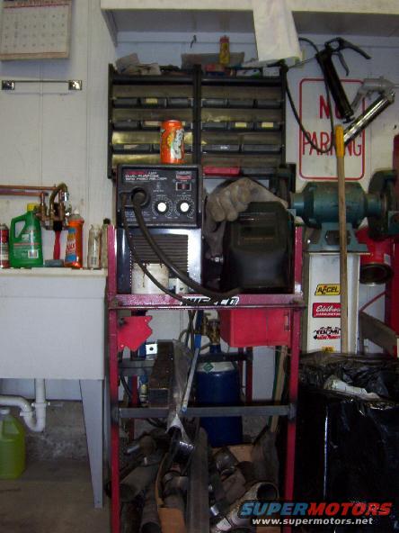 Welding machine, gas tank, tool chest, and workbench in a garage setting
