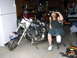 2000 Harley-Davidson Softail - A man sits next to his motorcycle in a garage. The motorcycle appears to be a Harley-Davidson.