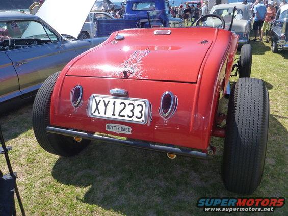 Red hot rod rear view with custom flames, license plate XY1233, and wide tires