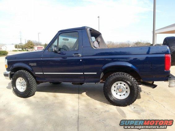 Dark blue Ford Bronco with removable top, side view, lifted suspension, off-road tires