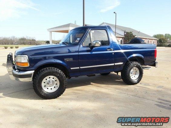 Blue 1995 Ford Bronco side view with aftermarket wheels and bull bar