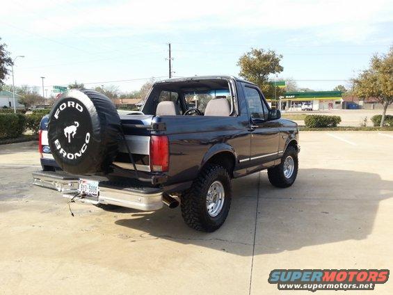 Dark blue Ford Bronco with spare tire on back, parked in lot