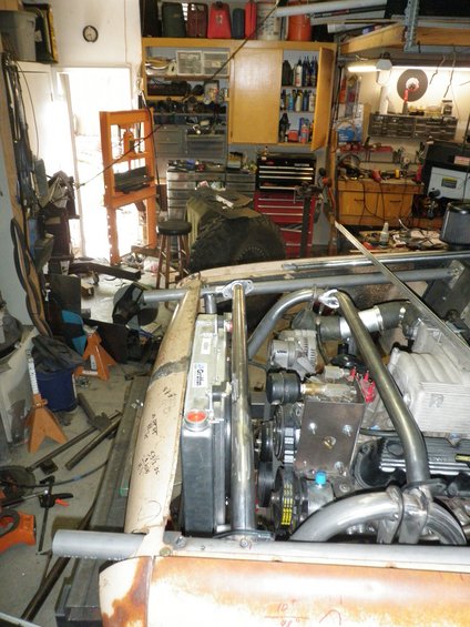 Engine bay with custom roll cage, radiator, and V8 engine