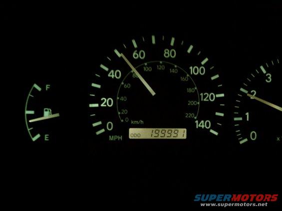 Car dashboard with fuel gauge and speedometer showing 199,991 miles on odometer