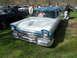 1973 Ford Ranchero - A two-tone blue and white station wagon, likely a 1957 model, is parked on a grassy field with a FOR SALE sign displayed in the window.