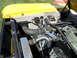 1973 Ford Ranchero - A close-up view of the engine bay, showing various components and wiring under the hood of a yellow vehicle.