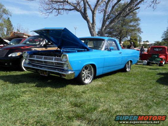 Blue 1966 pickup truck with hood open, custom wheels