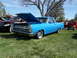 1973 Ford Ranchero - A bright blue pickup truck, possibly a 1966 model, is displayed with its hood open at a car show.