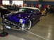 1973 Ford Ranchero - A custom purple 1950 Lincoln convertible is displayed indoors, with other vehicles and people in the background.