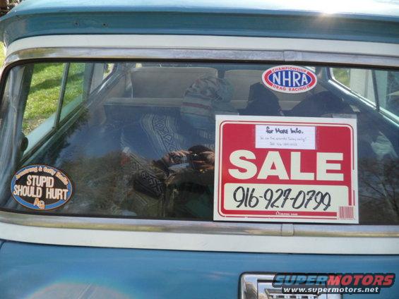 Rear window with a "SALE" sign and phone number, plus NHRA and "Stupid Should Hurt" stickers