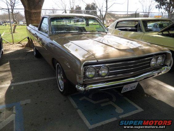 1970 Ford Ranchero parked in a handicapped spot, another car is visible to the right
