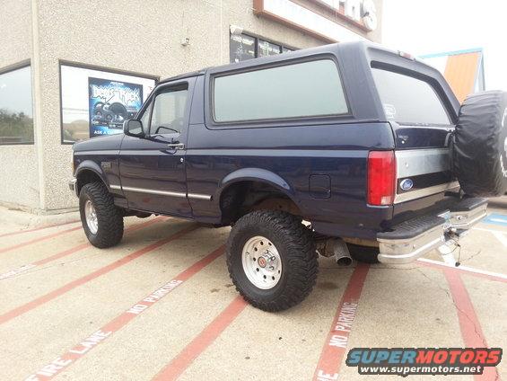 Blue 1995 Ford Bronco parked outside, rear view showing spare tire on tailgate