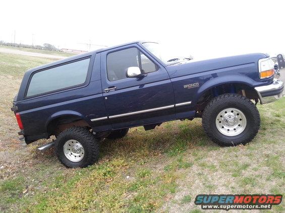 Blue 1995 Ford Bronco parked on grassy incline