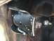 1996 Ford Bronco - Close-up of a vehicle's undercarriage shows a black metal spring hanger bracket with visible bolts and surrounding rust.