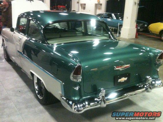 Rear view of a two-tone green and white 1955 Chevrolet Bel Air with hood open