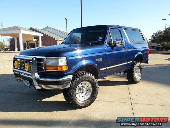 Blue 1995 Ford Bronco with aftermarket bumper and smiley face fog lights