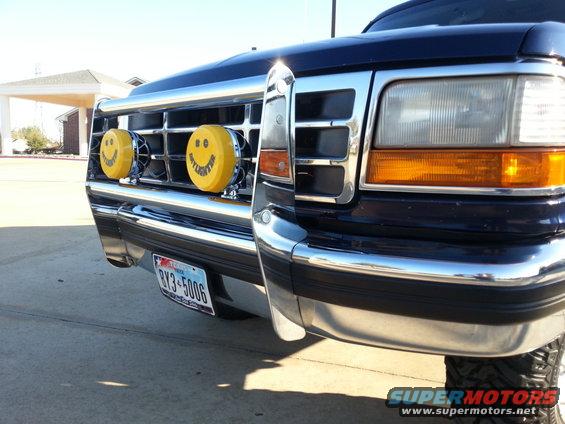 Front view of a 1995 Ford Bronco with chrome bumper and yellow smiley face lights