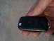 1997 Ford Taurus - A hand holds a black car key fob with lock, unlock, and trunk buttons.