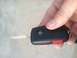 1997 Ford Taurus - A hand holds a Ford key fob with a red panic button and the Ford logo visible.