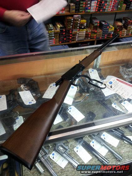 Lever-action rifle with wooden stock and blued barrel on display