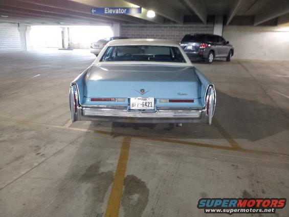 Light blue Cadillac sedan parked in a garage, rear view. License plate reads BPP-6421