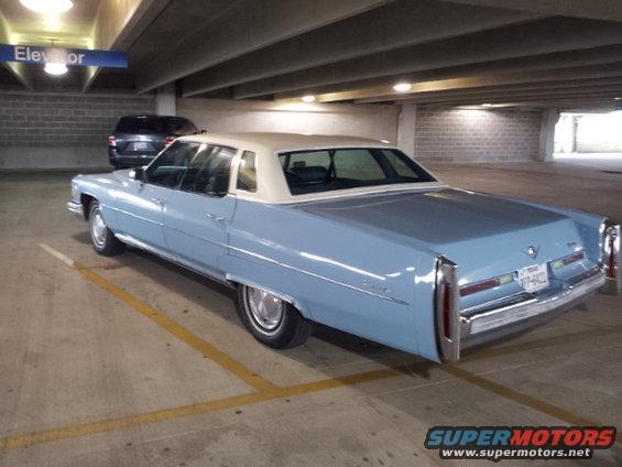 Light blue Cadillac sedan with a white vinyl roof parked in a garage, 3q-front view