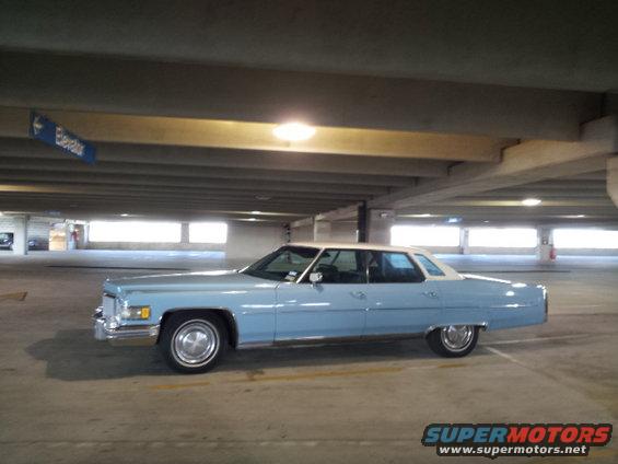light blue sedan with white roof parked in a parking garage
