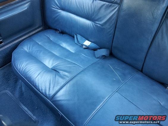 Blue leather rear seat with seatbelt and scratches