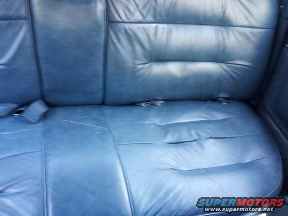 Blue leather rear car seats with visible seat belts