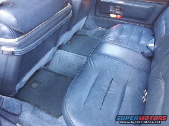 Blue leather rear seats and carpeted floor of a car interior