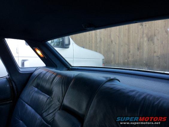 Interior rear seat view with a white van visible through the window