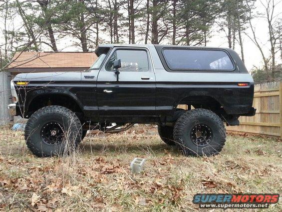 Side view of a lifted 1978 Ford Bronco with large tires, parked outdoors