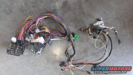Wiring harness with fuse box, connectors, and labels on a gray surface
