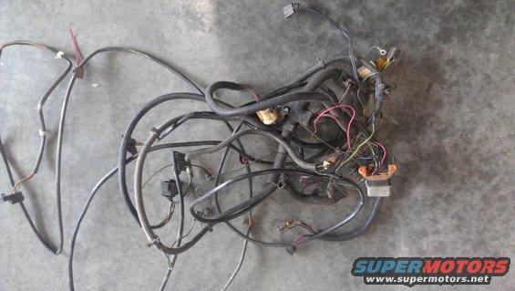 Tangled automotive wiring harness with connectors and black protective loom