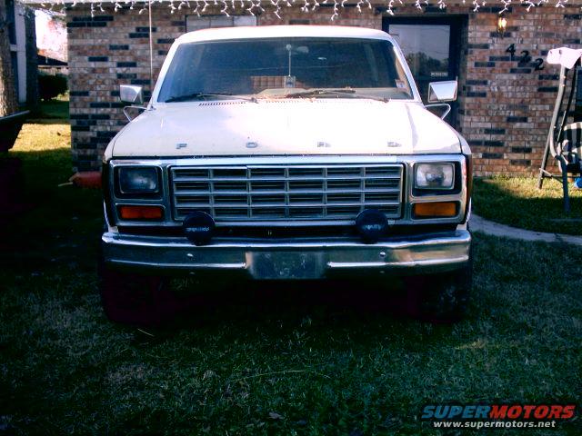 Front view of a white Ford F-Series truck with a chrome grille and bumper