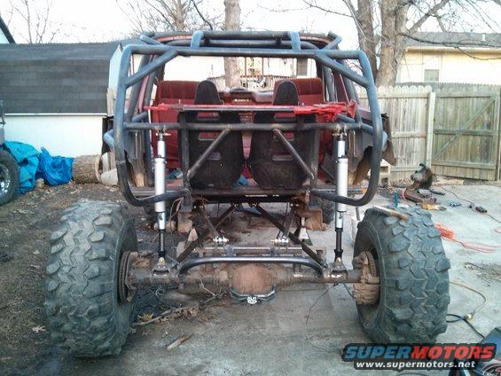 Rear view of off-road buggy with roll cage, large tires, and custom suspension